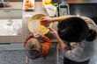 © Santi Nuñez/Stocksy - Happy family cooking together