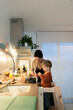 © Santi Nuñez/Stocksy - Happy family cooking together
