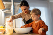 © Santi Nuñez/Stocksy - Mother and son baking together at home