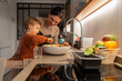 © Santi Nuñez/Stocksy - Happy family cooking together
