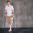 Portrait, crutches and man with disability in healthcare centre for walking, muscle strength and medical for support. Amputee, exercise and physiotherapy for physical therapy with rehabilitation
