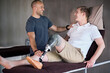 © peopleimages.com - Physiotherapy, man and amputee patient on hospital bed for checkup, recovery and rehabilitation. Support, strength and mobility training for person with disability in clinic with physio therapist