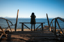 Woman On Wooden Platform Watching The Ocean