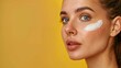 © Diego - Beautiful young woman with sun protection cream on her face against orange background, closeup. Space for text