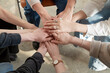 © Danil Nevsky/Stocksy - Crop people stacking hands while sitting on chairs