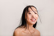 © Asya Molochkova/Stocksy - Happy asian woman with studio light