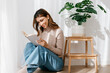 © Tania Cervian/Stocksy - Smiling woman reading literature while sitting on floor