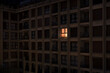 © Ibai Acevedo/Stocksy - Lonely illuminated apartment window at night