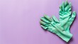 Pair of green rubber gloves on purple background