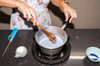 © Alvaro Lavin/Stocksy - Close-up of a woman cooking in a pot.