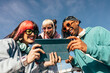 © VICTOR TORRES/Stocksy - Multi-ethnic friends enjoying tech outdoors on a sunny day
