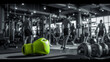A green boxing glove sits on a bench in a gym