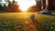 A close up of a golf ball on the green with the sun rising in the background.