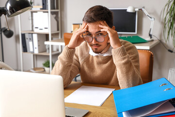 Canvas Print - Stressed young man working under deadline in office