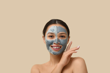 Poster - Young woman with clay mask on her face against beige background