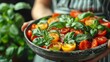   A tight shot of a hand holding a bowl filled with food Toppings include tomatoes and basil