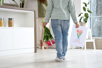 Wall Mural - Little girl with bouquet of tulips and drawing going to greeting her mom with Mothers Day in room