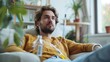 Thoughtful man receiving intravenous therapy sitting on a sofa in a cozy living room