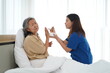 © pixs4u - Asian young caregiver female feeding aged woman on bed at home