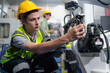 © Nassorn - Robotic engineer examining robot arm machine for repairing service. Modern technology technician working on hardware maintenance to fix AI mechanical part of futuristic industrial automated equipment.