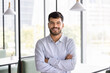 © fizkes - Happy handsome company director man in formal shirt looking at camera with hands folded and toothy smile. Cheerful business professional, executive, entrepreneur head shot portrait