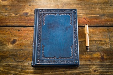 Wall Mural - Aged blue leather journal lay down to wooden table