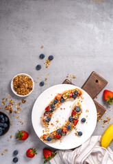 Wall Mural - Banana Topped with Granola and Berries, Healthy Snack and Breakfast Idea