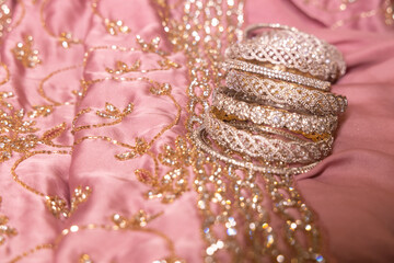 Wall Mural - stone studded bangles spread on a  delicate intricately designed satin lehenga