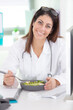 beautiful woman doctor holding a plate with fresh vegetables