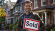 happy single man standing in front of his new home, holding a 