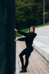 Wall Mural - Young female workout before fitness training session at the park. Healthy young woman warming up outdoors. She is stretching her arms and looking away,hi key.