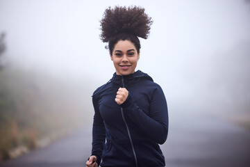 Wall Mural - Girl, running and smile in morning fog in nature for health, fitness or wellness on road in portrait. Woman, person and athlete in workout, training and outdoor for speed, cardio and winter in Canada