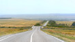A beautiful asphalt road with markings with descents and climbs goes into the distance. Beautiful road in the Kolmyk steppe.
