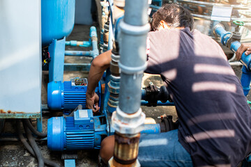 Selective focus to hand of plumber repair and remove motor of centrifugal water pump. Plumbers working to installation centrifugal water pump motor.