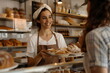 © dobok - Portrait of a young woman working in a bakery giving a plate of pastry to a costumer