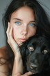 Woman With Blue Eyes Holding Black Dog