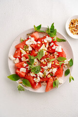 Wall Mural - Salad of watermelon and soft cheese with mint, light background, no people, top view