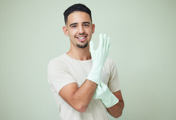 Poster - Man, cleaner and portrait with gloves in studio for housework, spring cleaning and housekeeping. Person, face and happy with protection for dirt, dust or safety for domestic chores on lime background