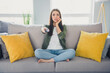© deagreez - Full size photo of pretty young sit couch watch tv woman wear shirt modern interior apartment indoors