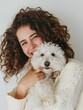 Warm portrait of a young woman hugging her fluffy white dog, expressing joy and affection.