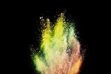 Fototapeta Tęcza - abstract powder splatted background. Freeze motion yellow powder explosion on black background
