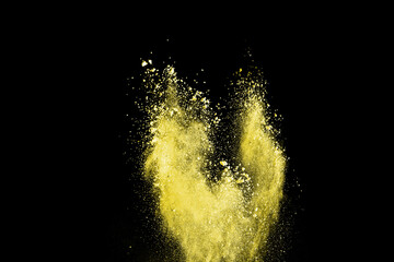 Wall Mural - abstract powder splatted background. Freeze motion yellow powder explosion on black background