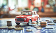 Red car on the table among the coins. Concept of buying, renting, insuring or leasing a car
