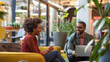 Inside a cozy corner of a modern office space, a man and woman engage in a strategic discussion, their smiles suggesting a meeting of minds and a positive outlook on their project'