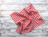 Fototapeta Tulipany - Red checkered picnic cloth top view on rustic wooden background empty copy space.