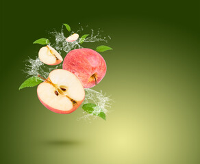 Wall Mural - Water splash on fresh apple with leaves isolated on green background