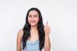 Young woman in baby blue dress giving thumbs up on white background