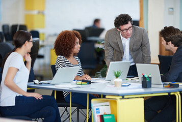 Canvas Print - Collaboration, business and conversation in office for brainstorming new company, workshop and internship. Men, women and teamwork at desk with laptop for web design, planning and startup project