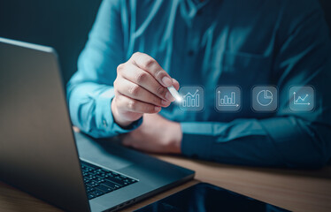 Wall Mural - future, global, working, digital, social, network, innovation, system, security, tech. A man is holding a stylus on a laptop screen with a graph on it. The graph is a line graph with a downward trend.