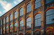 A photograph of an old warehouse converted into a trendy loft apartment complex, retaining original